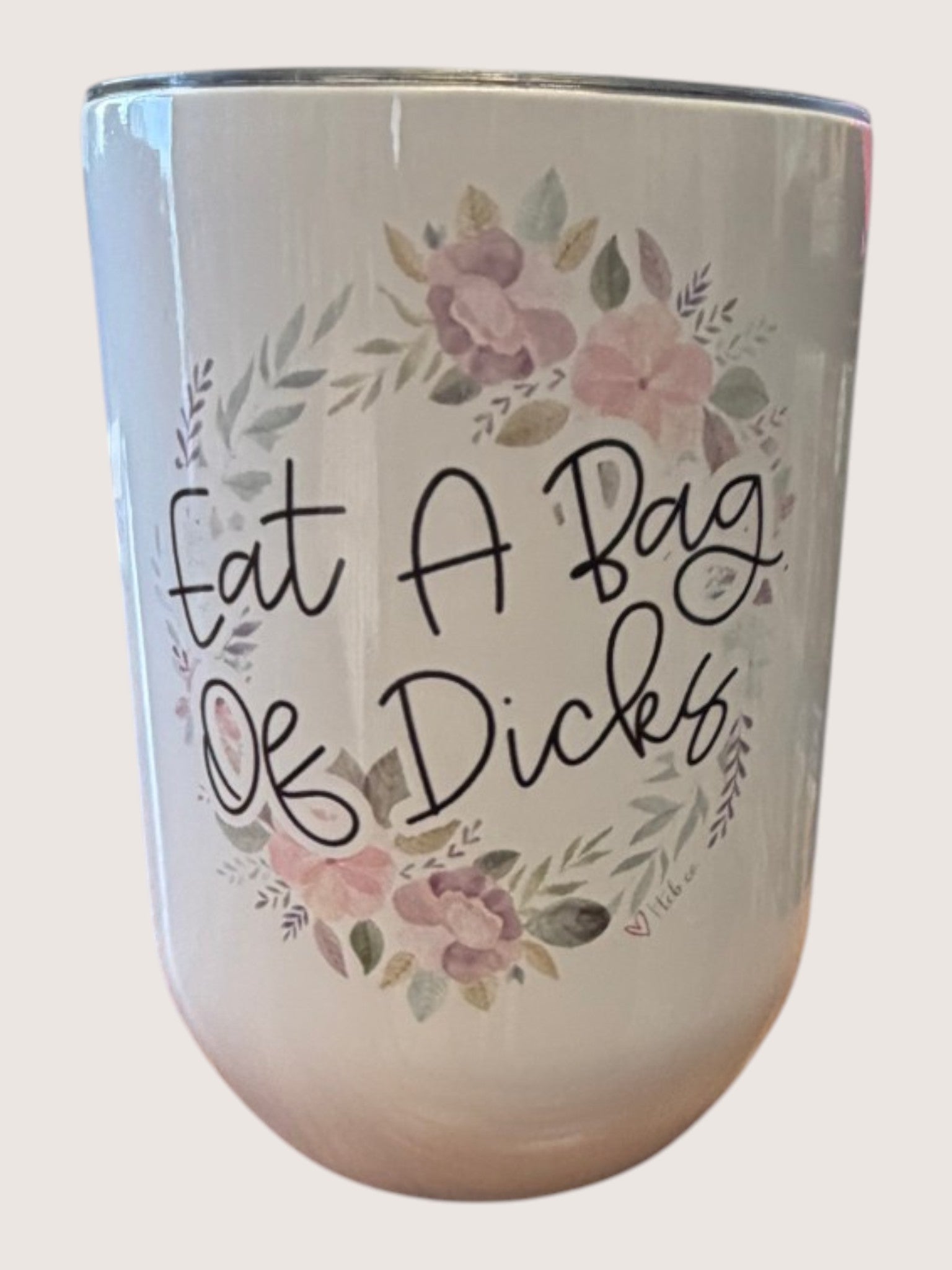 Tumbler with floral design and text on a white background