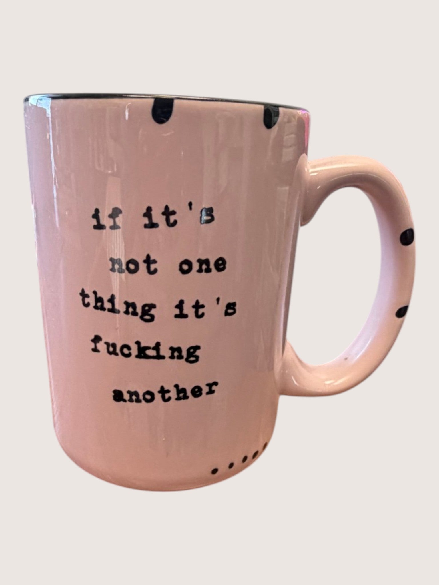 Pink mug with black text on a light gray background