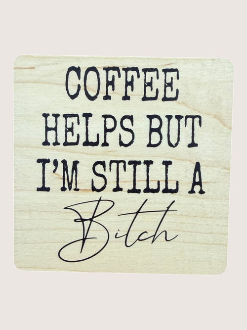 Wooden Coaster with text 'COFFEE HELPS BUT I'M STILL A BITCH' on a light background