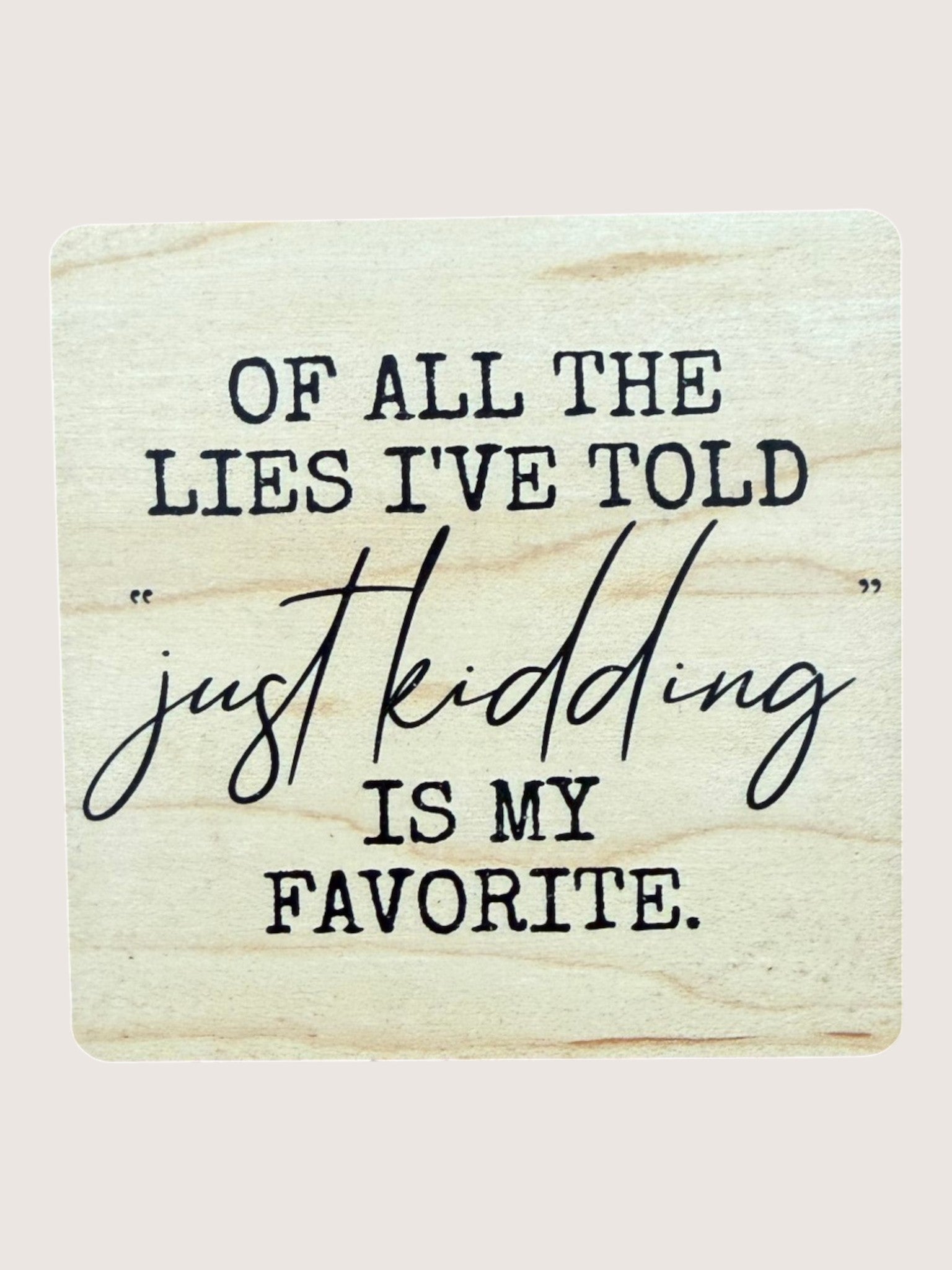 Wooden Coaster with humorous text 'Of all the lies I've told, just kidding is my favorite.'