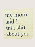 Wooden coaster with text 'my mom and I talk shit about you' on a light background