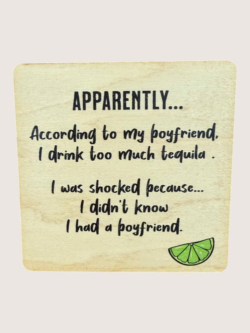 Wooden coaster with humorous text about drinking tequila and a lime graphic on a light background