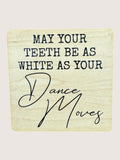 Wooden coaster with humorous dental and dance-themed text on a beige background