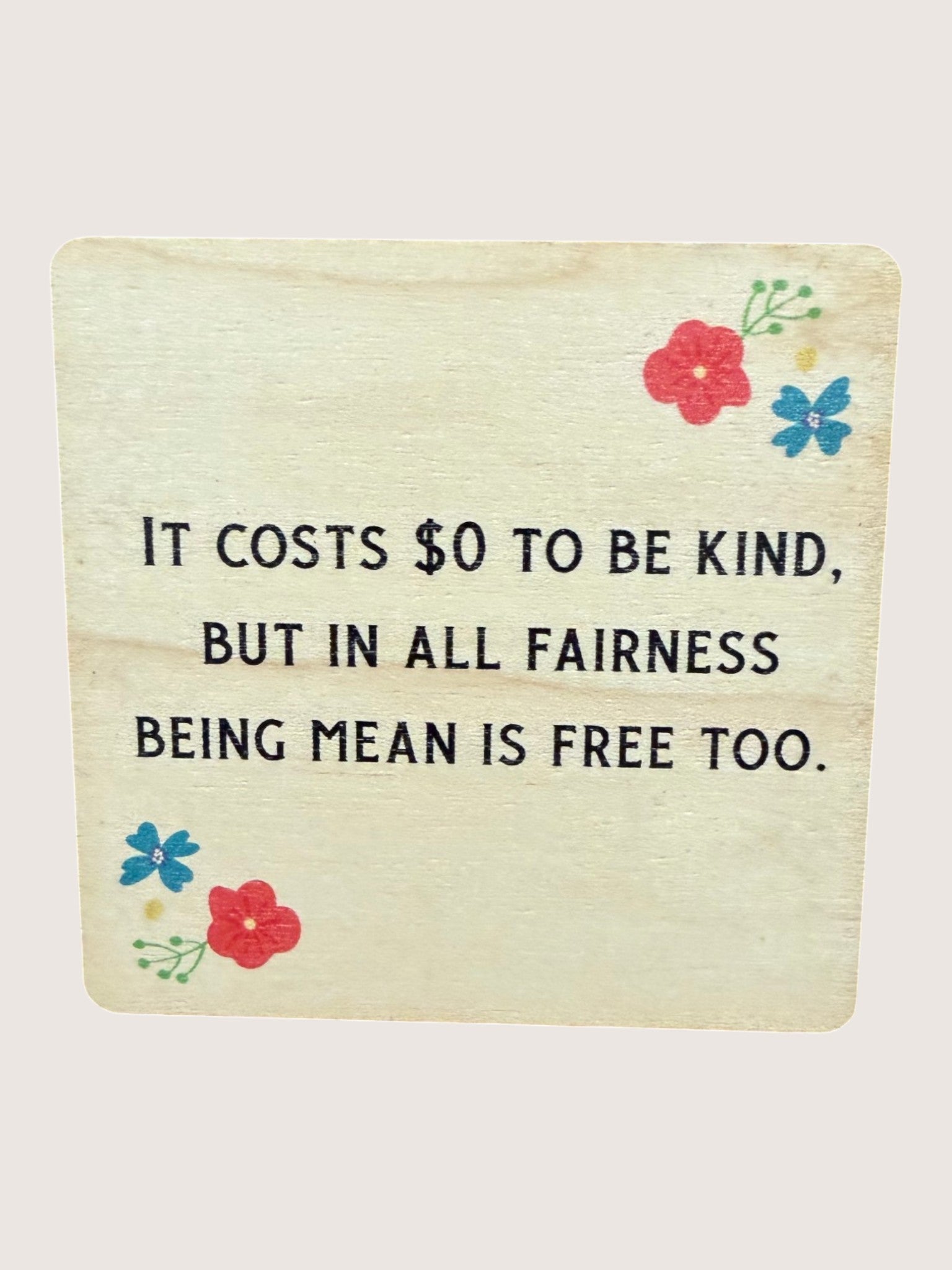 Motivational quote coaster with flowers on a light background