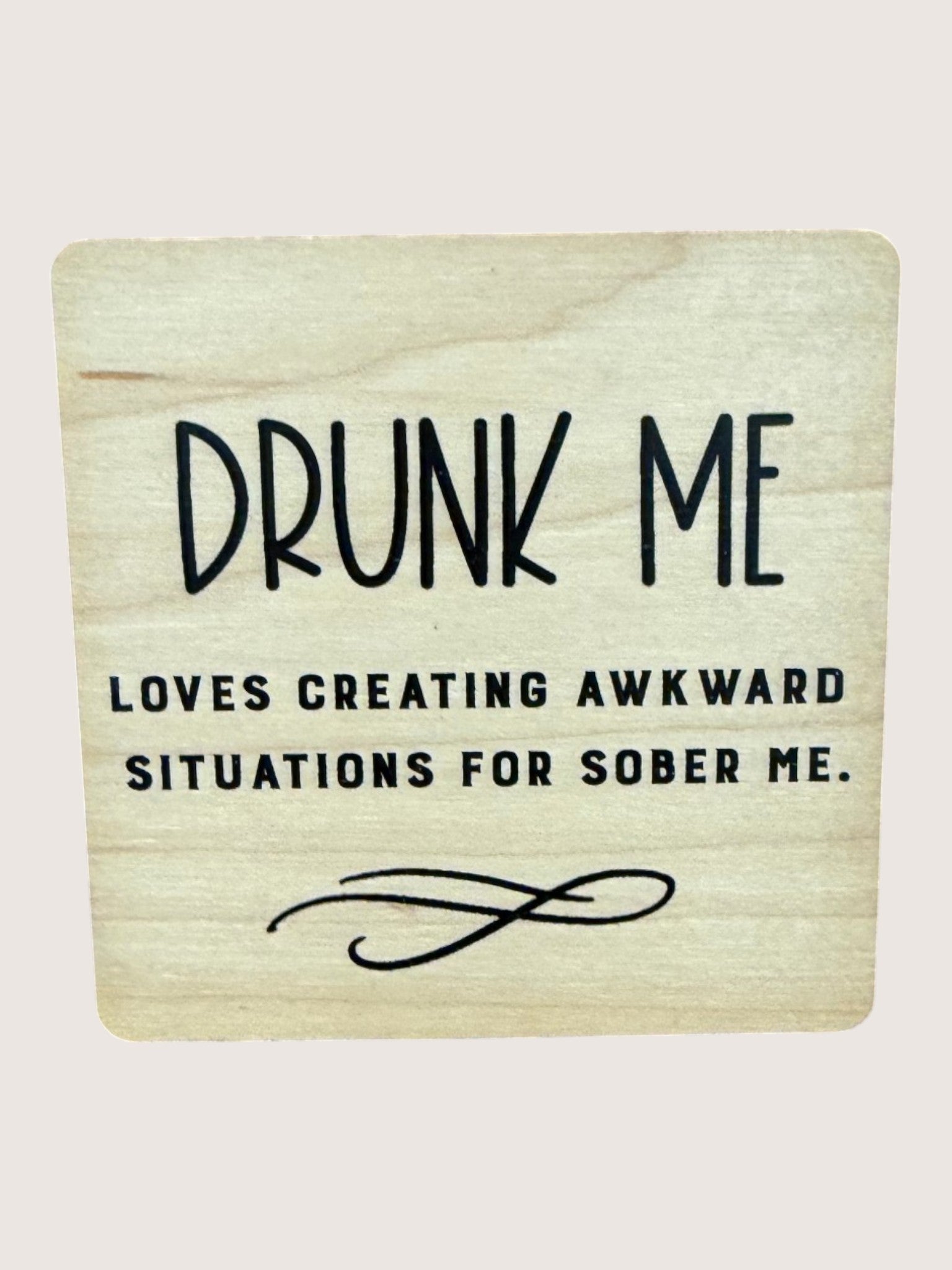 Wooden coaster with humorous text on a light background
