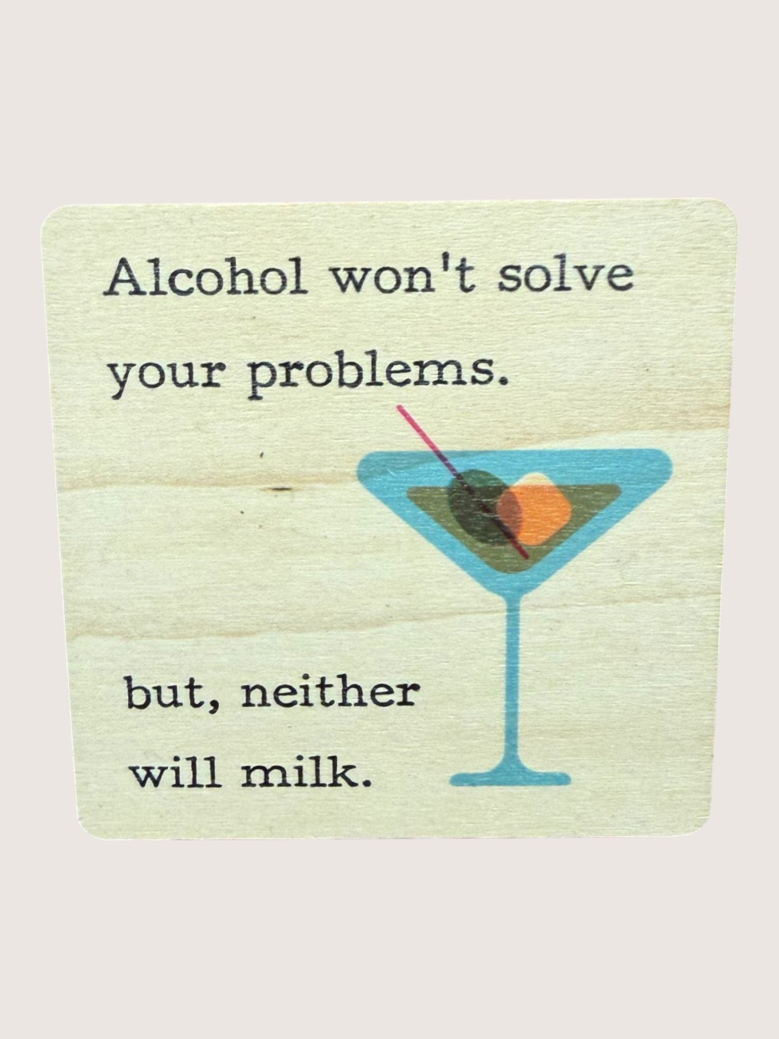coaster with Motivational quote about alcohol and milk with a martini glass graphic on a light background
