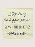 Wooden coaster with humorous text 'Stop being the bigger person, slash their tires.'