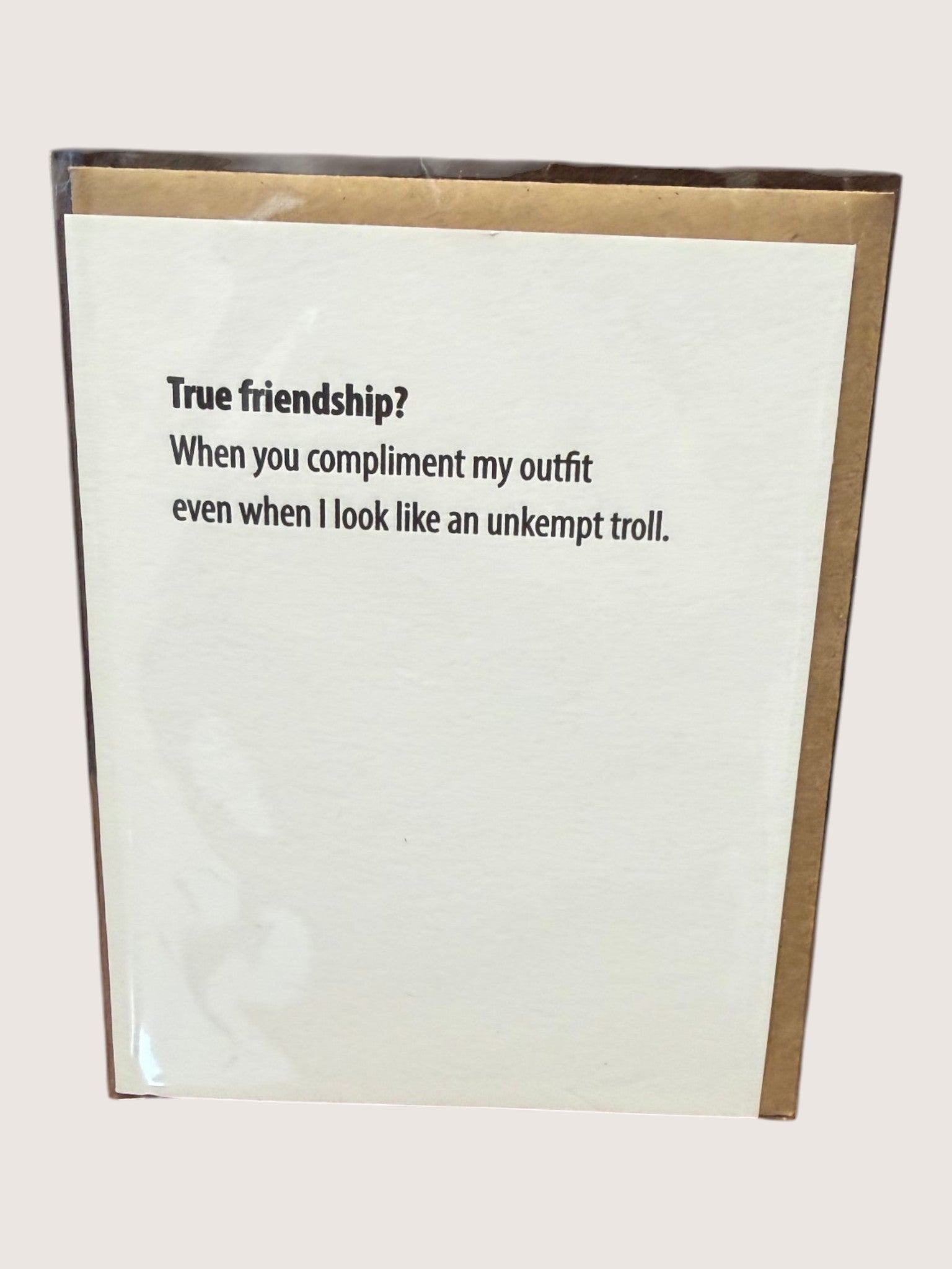Card with humorous text about true friendship and outfit compliments.