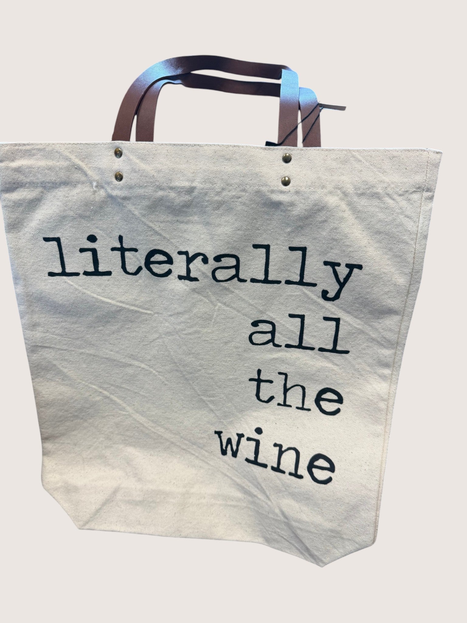 Tote bag with 'literally all the wine' text on a light background