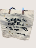 Tote bag with text 'Nothing in this bag belongs to me #momlife' on a light background
