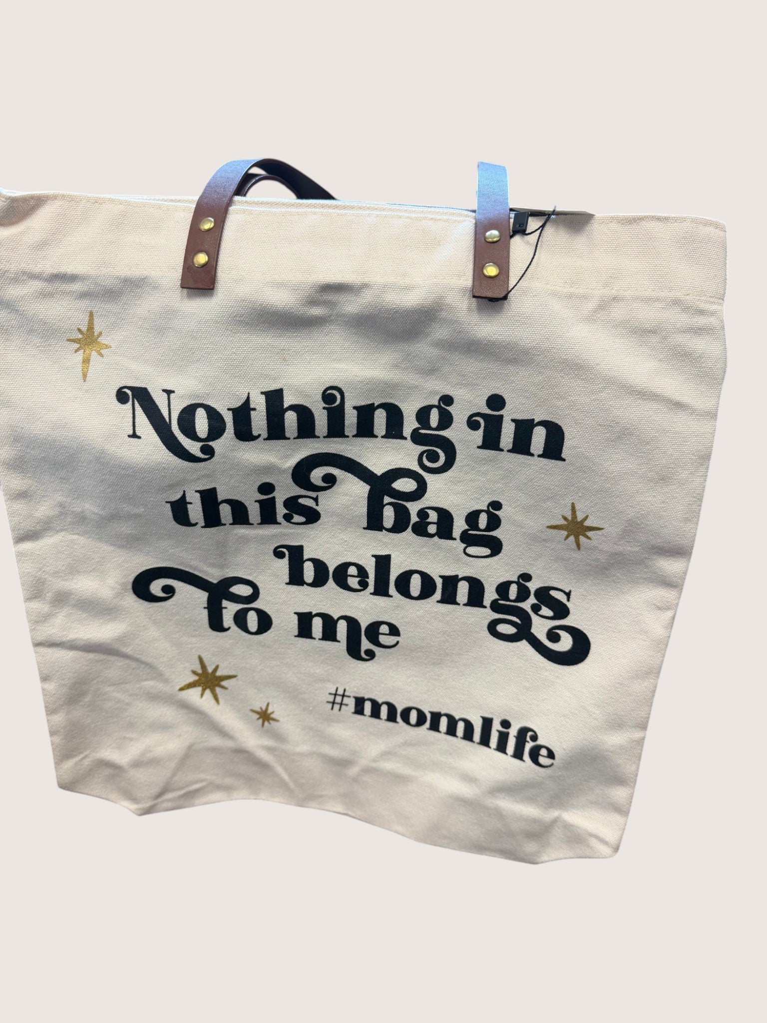 Tote bag with text 'Nothing in this bag belongs to me #momlife' on a light background