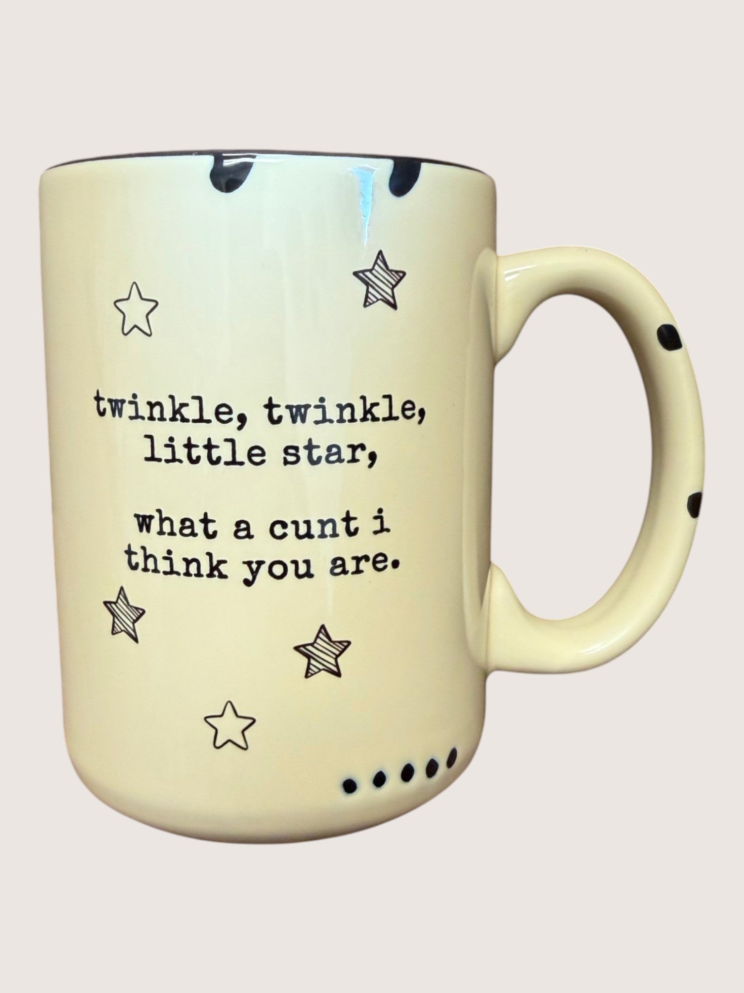 Mug with star pattern and humorous text on a light background