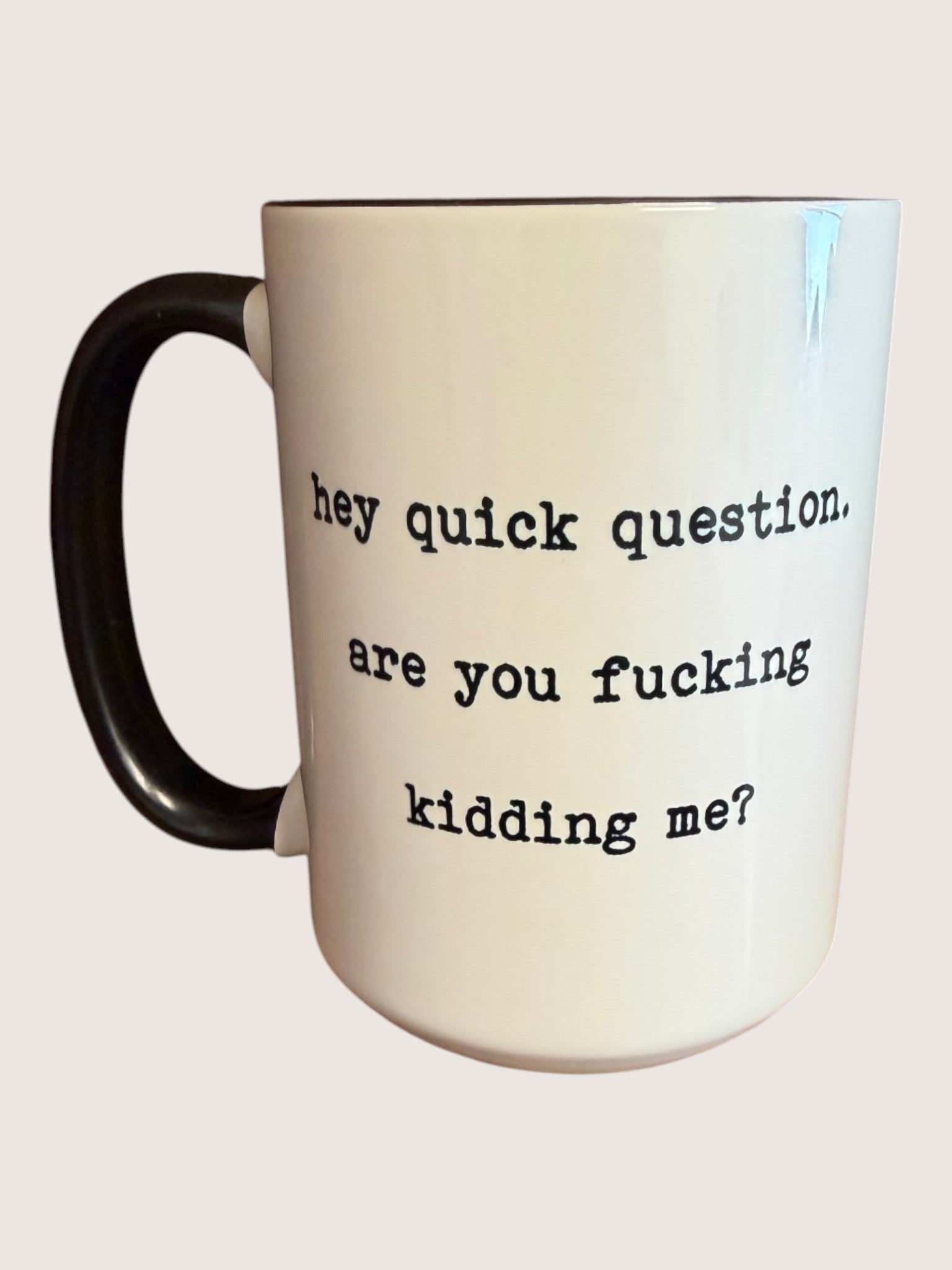 Mug with text 'hey quick question, are you fucking kidding me?' on a beige background