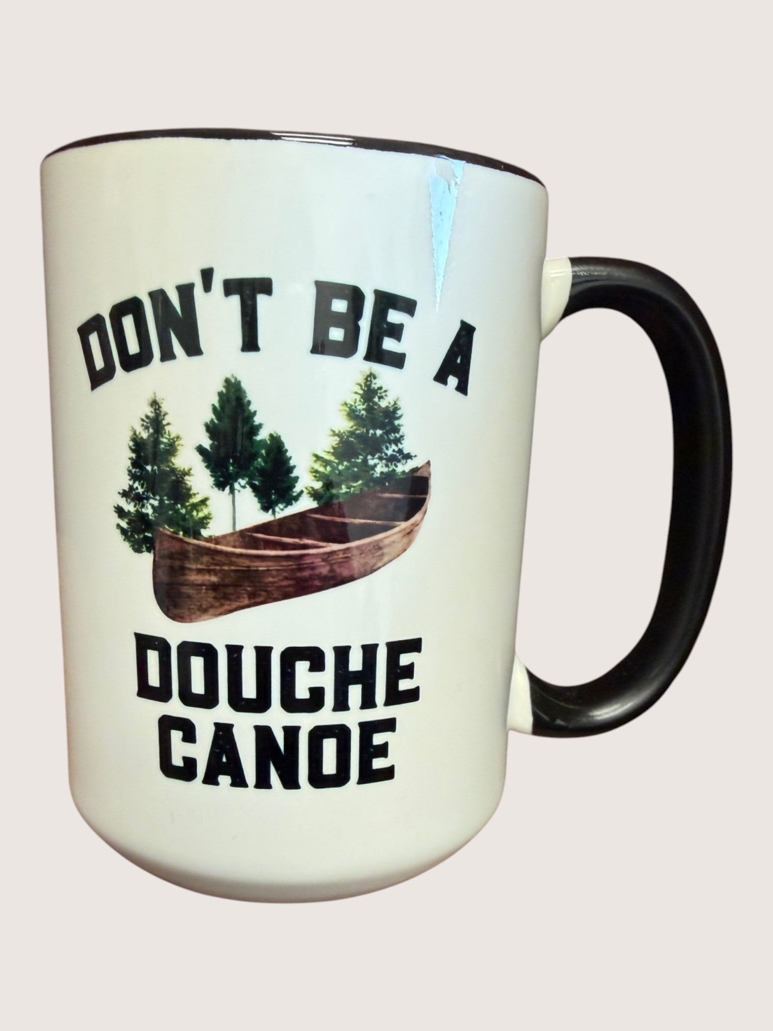 Mug with 'Don't be a Douche Canoe' text and graphic on a light background