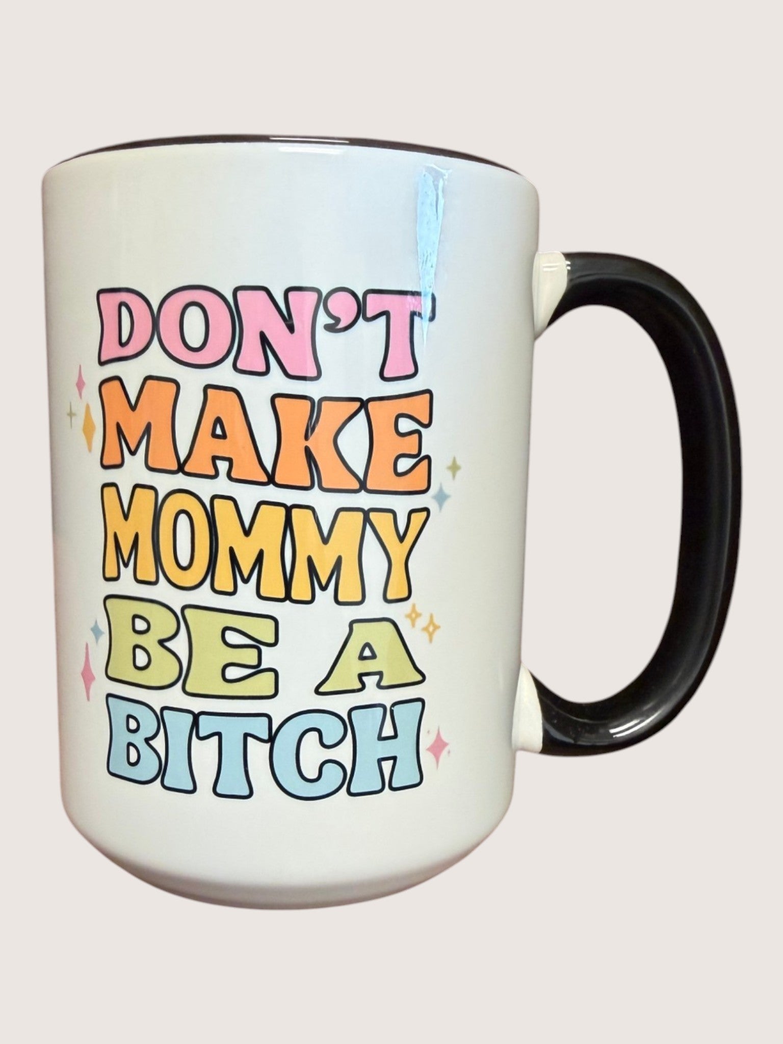 Mug with colorful text 'DON'T MAKE MOMMY BE A BITCH' on a light background