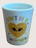 shot glass with a heart-shaped waffle design and text on a light background