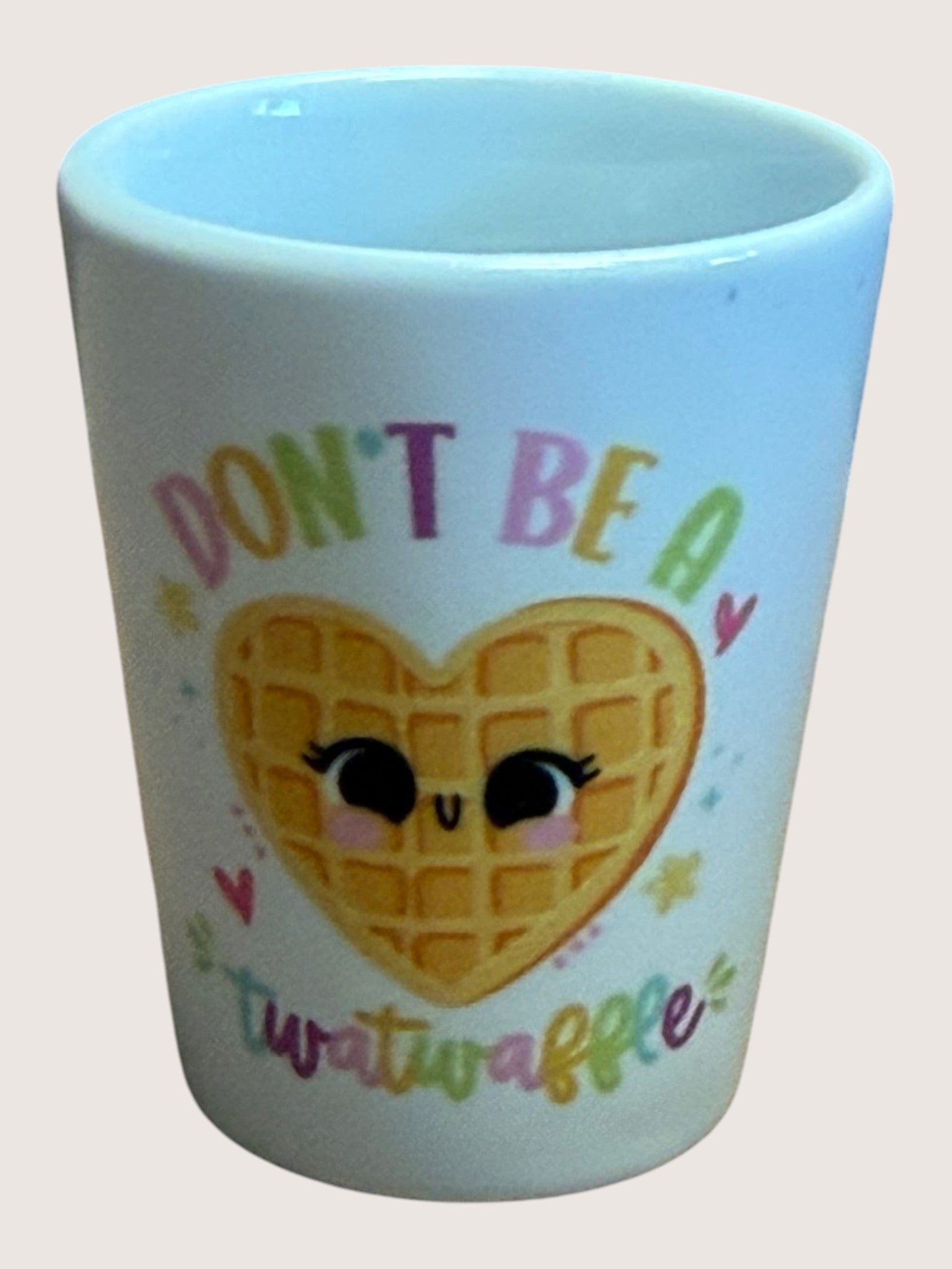 shot glass with a heart-shaped waffle design and text on a light background