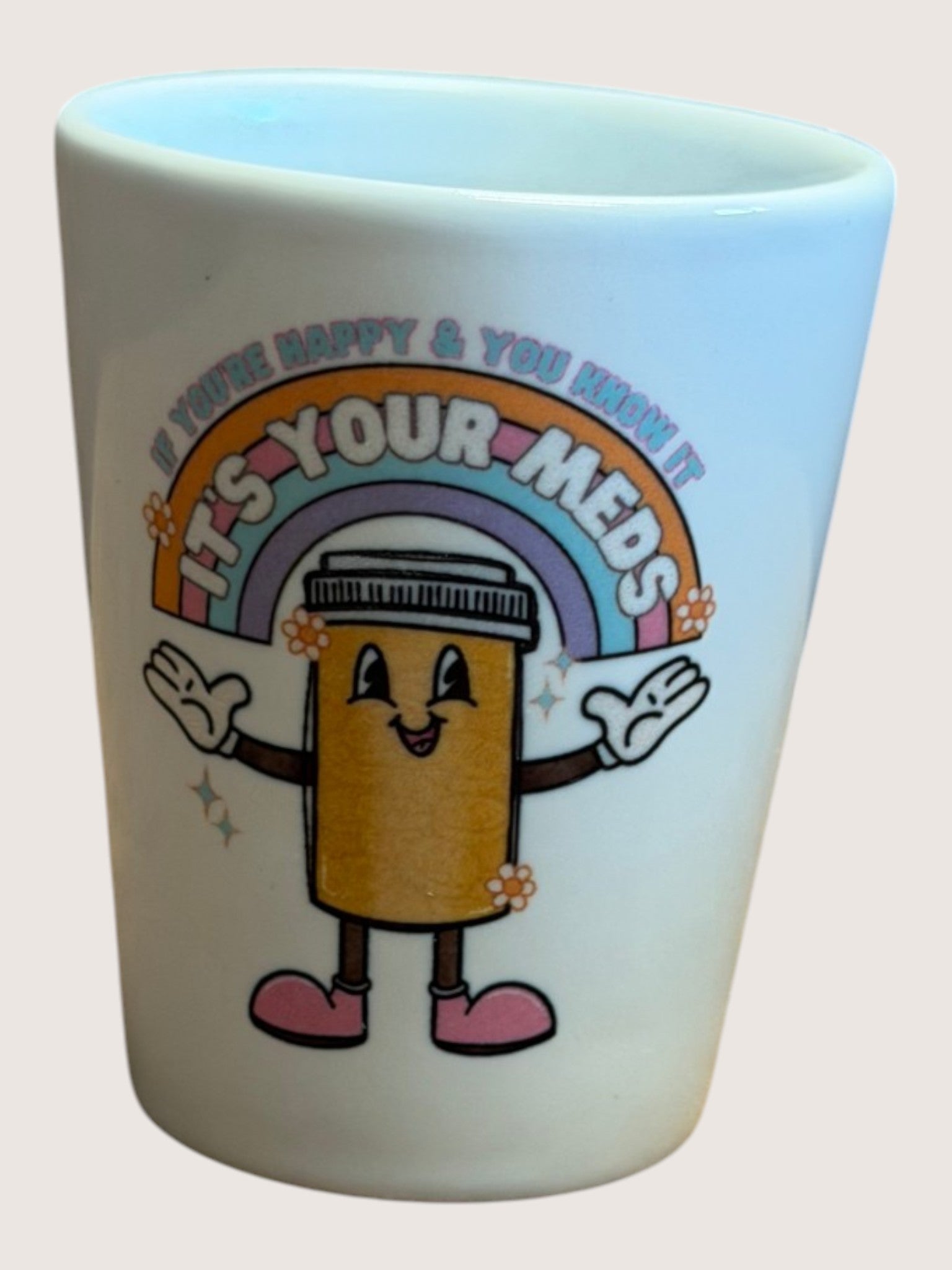 White mug with cartoon character and text 'It's Your Meds' on a light pink background