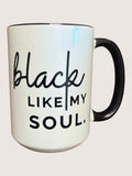 White mug with black text 'black like my soul' on a light pink background