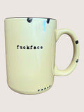 Mug with the word 'fuckface' printed on it against a plain background