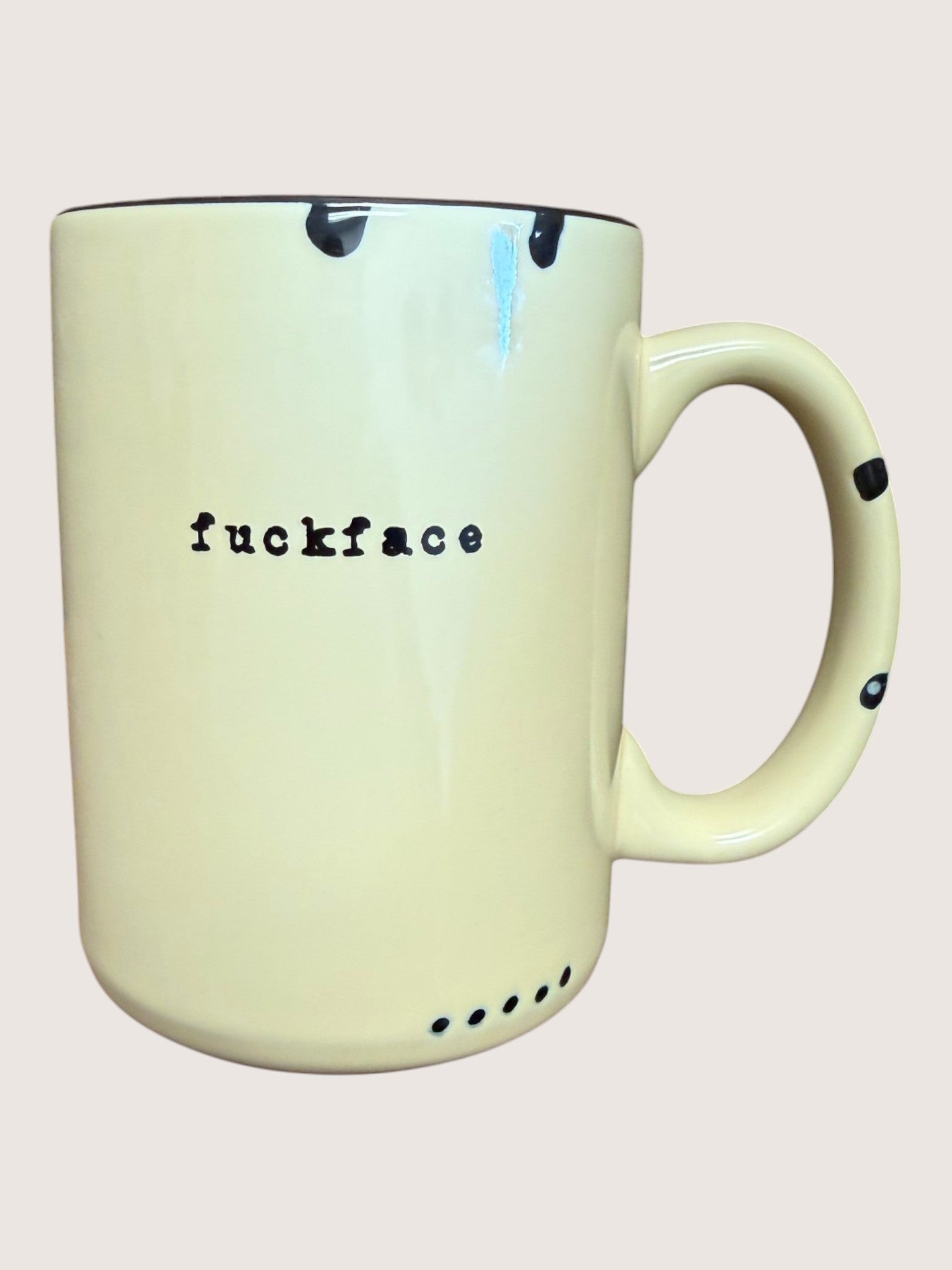 Mug with the word 'fuckface' printed on it against a plain background