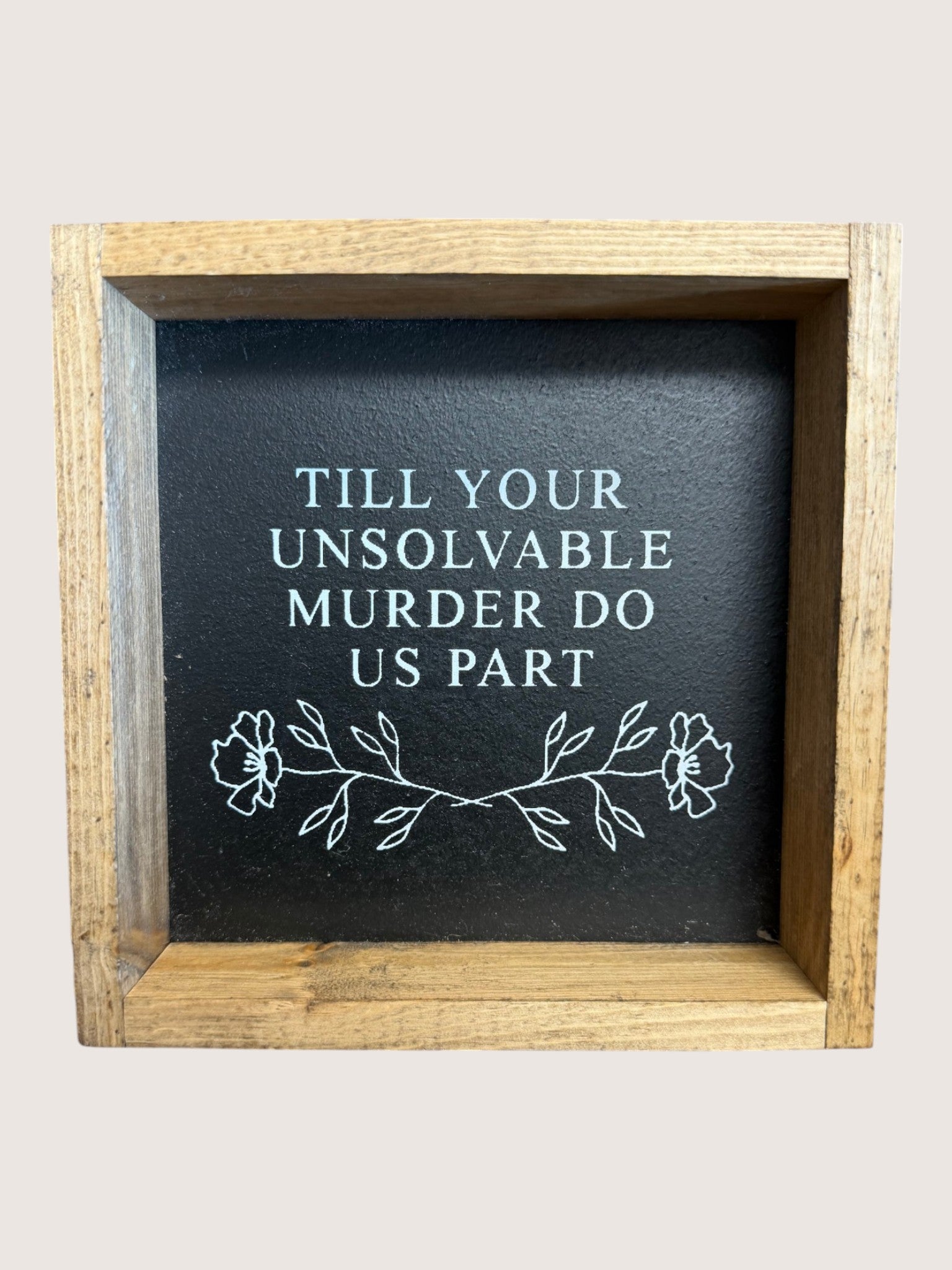 Wooden-framed sign with text 'Till your unsolvable murder do us part' on a black background