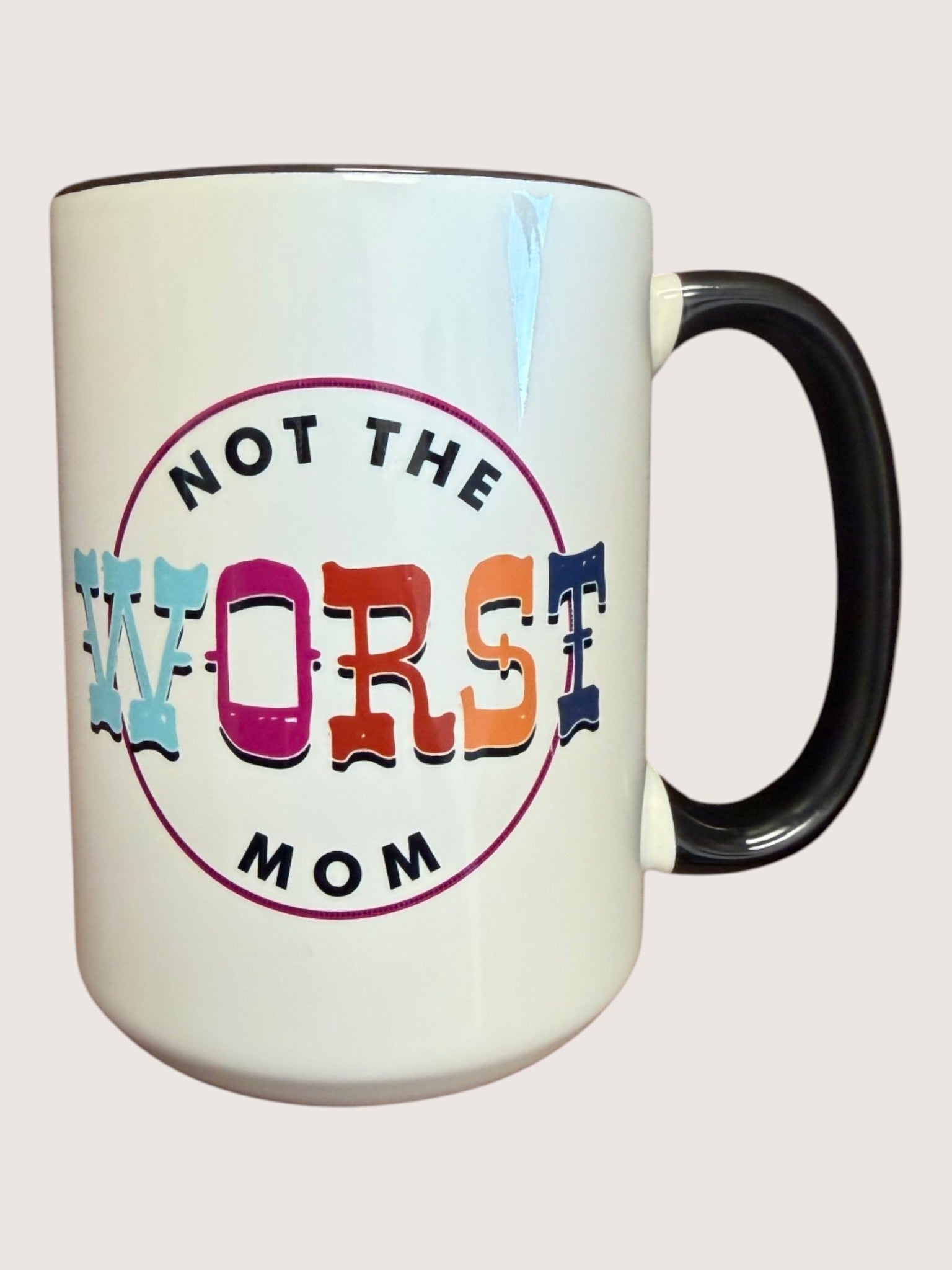 White mug with colorful text 'Not the Worst Mom' on a light gray background