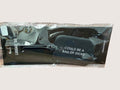 Black luggage tag with text in clear packaging on a light gray background