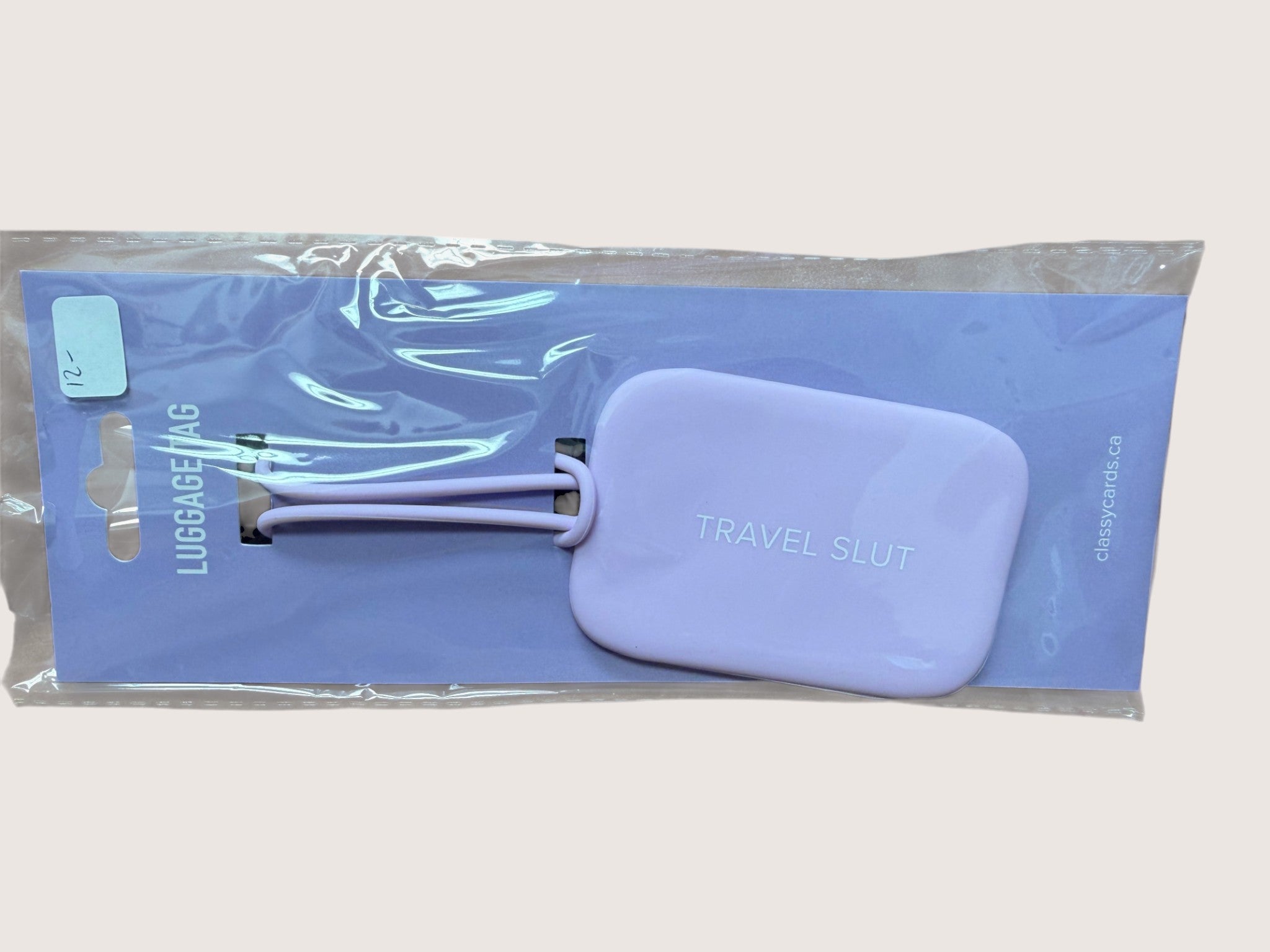 Purple luggage tag packaging on a light gray background