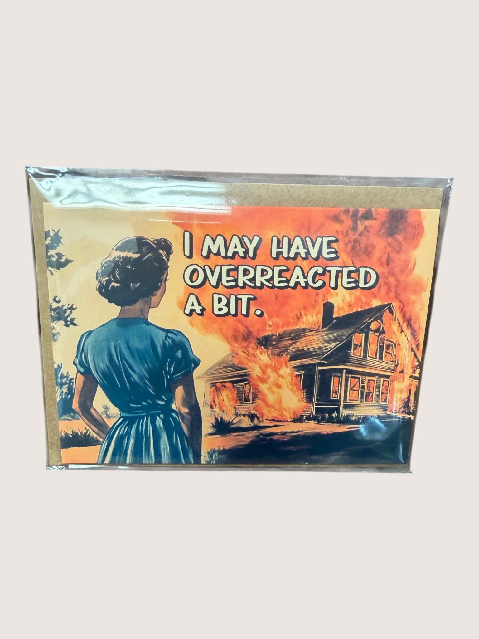 Packaged card with a graphic of a woman looking at a burning house and text 'I may have overreacted a bit.'
