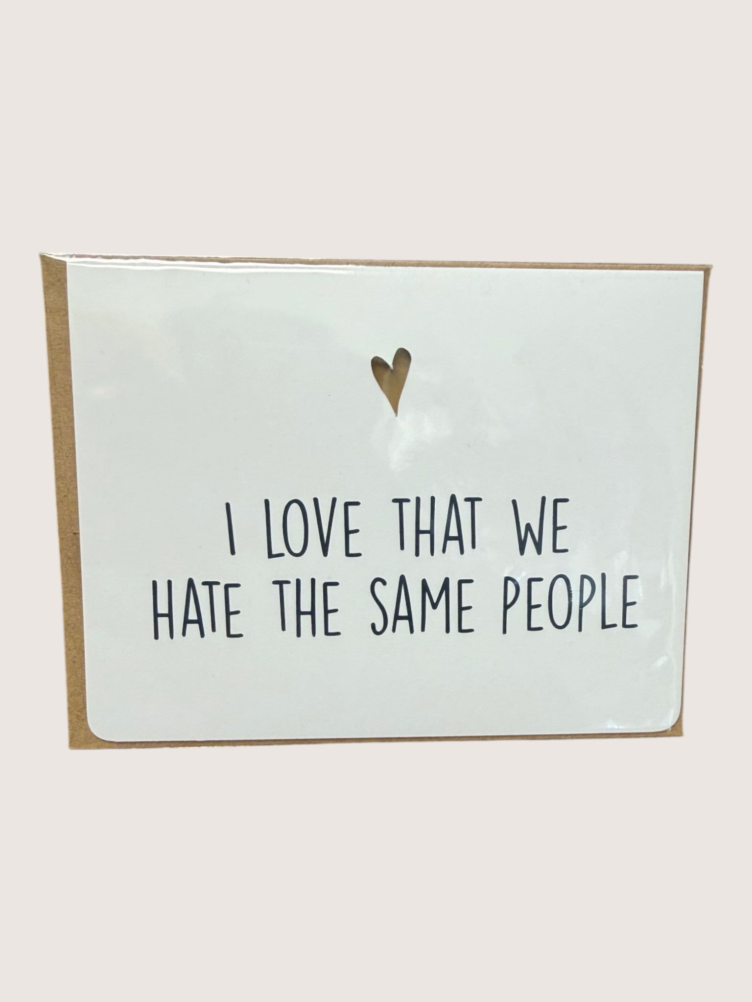 Card with text 'I love that we hate the same people' and a heart symbol on a light background