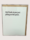 Card with text 'Well look at you just piling on the years.' on a light blue background with a gold border.