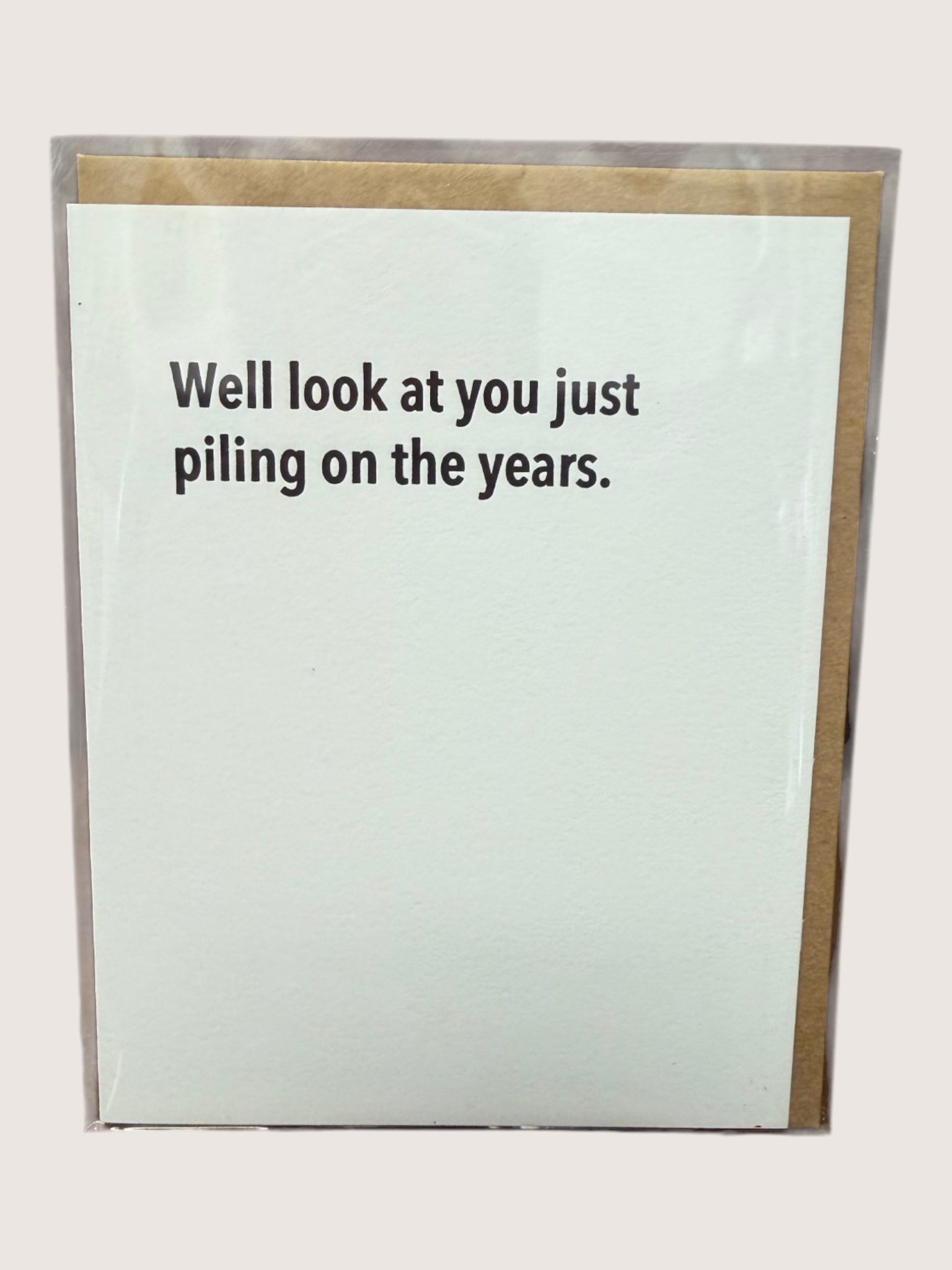 Card with text 'Well look at you just piling on the years.' on a light blue background with a gold border.