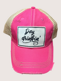Pink cap with 'Day drinkin'' patch on a light gray background