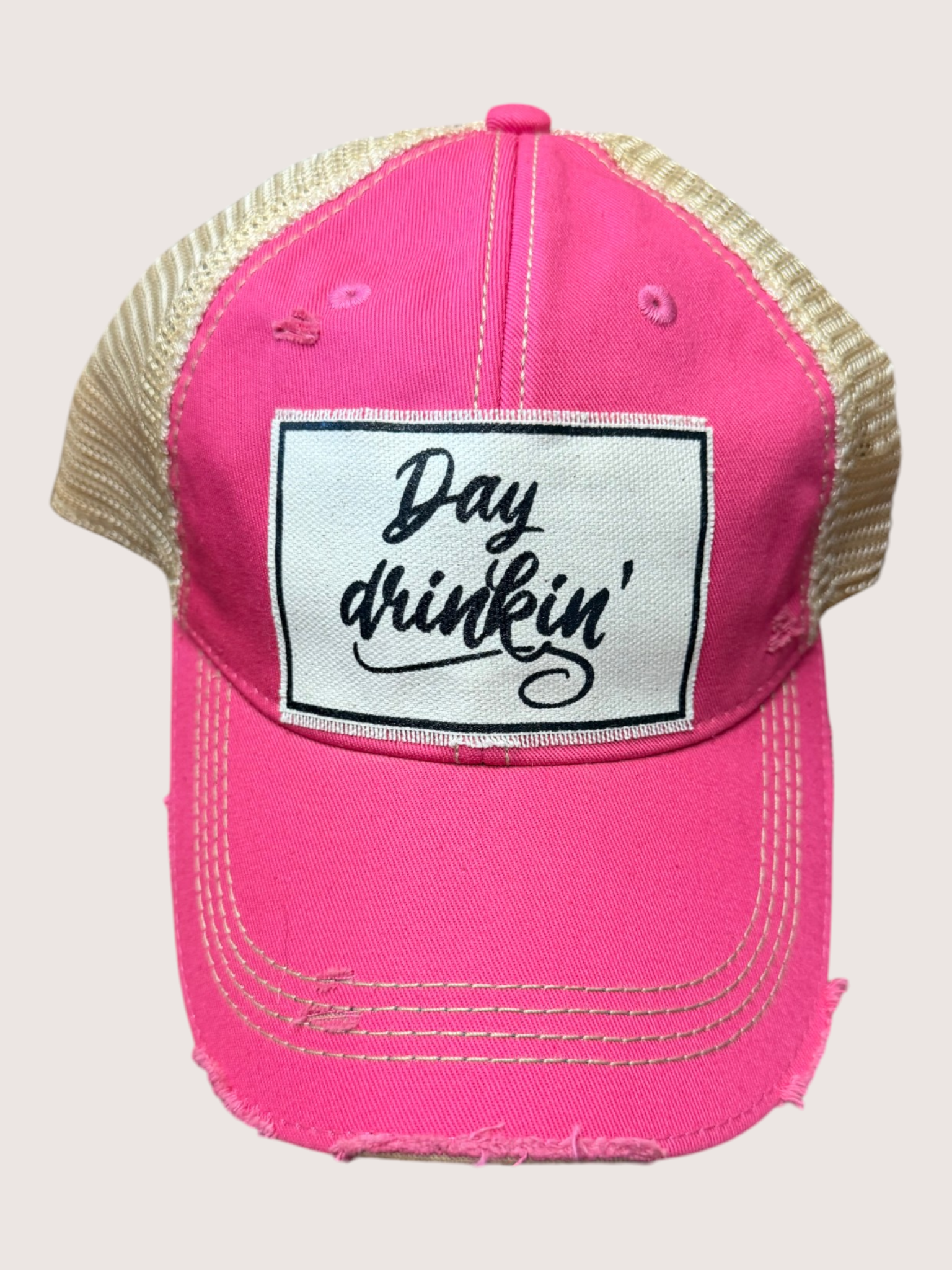 Pink cap with 'Day drinkin'' patch on a light gray background