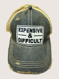 Distressed cap with 'EXPENSIVE & DIFFICULT' patch on a light gray background