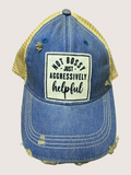 Blue denim cap with yellow mesh back and text patch on a light pink background