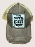 Vintage-style cap with 'I Like Coffee and Maybe Three People' patch on a beige background