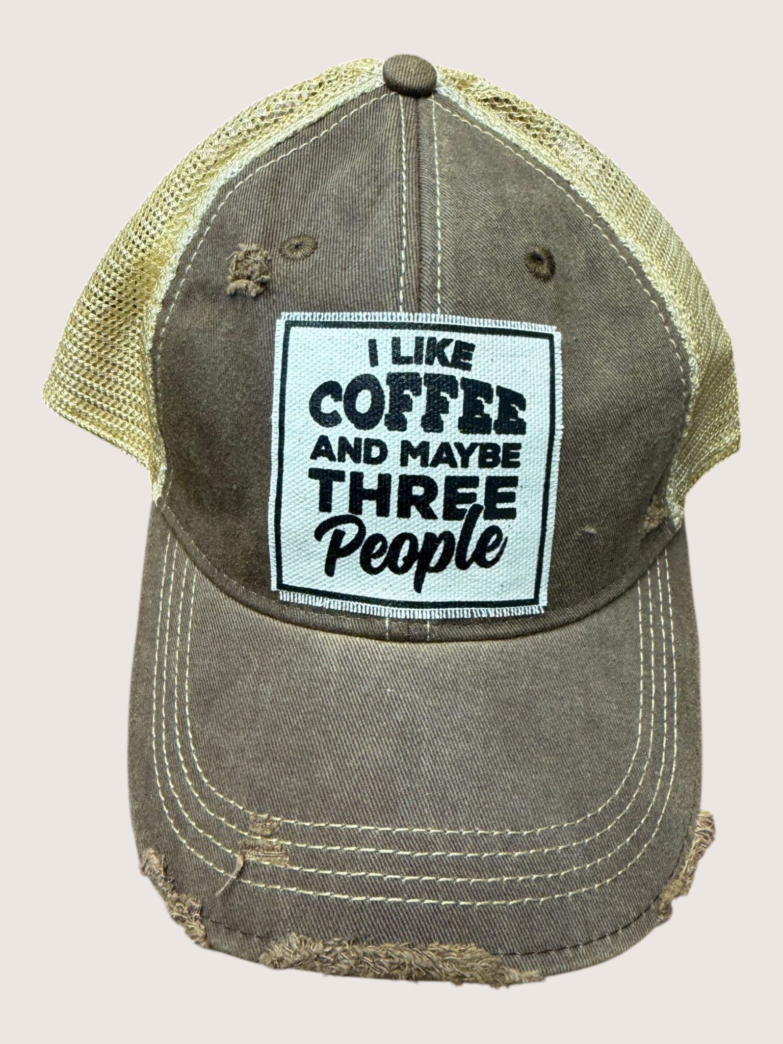 Vintage-style cap with 'I Like Coffee and Maybe Three People' patch on a beige background