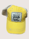 Yellow cap with a black and white patch on a light beige background