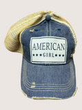 Blue denim cap with 'American Girl' logo on a light pink background
