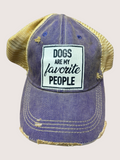 Blue denim cap with yellow mesh back and 'Dogs are my favorite people' patch on a light gray background