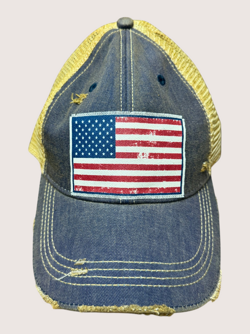 Blue denim cap with American flag patch on a beige background