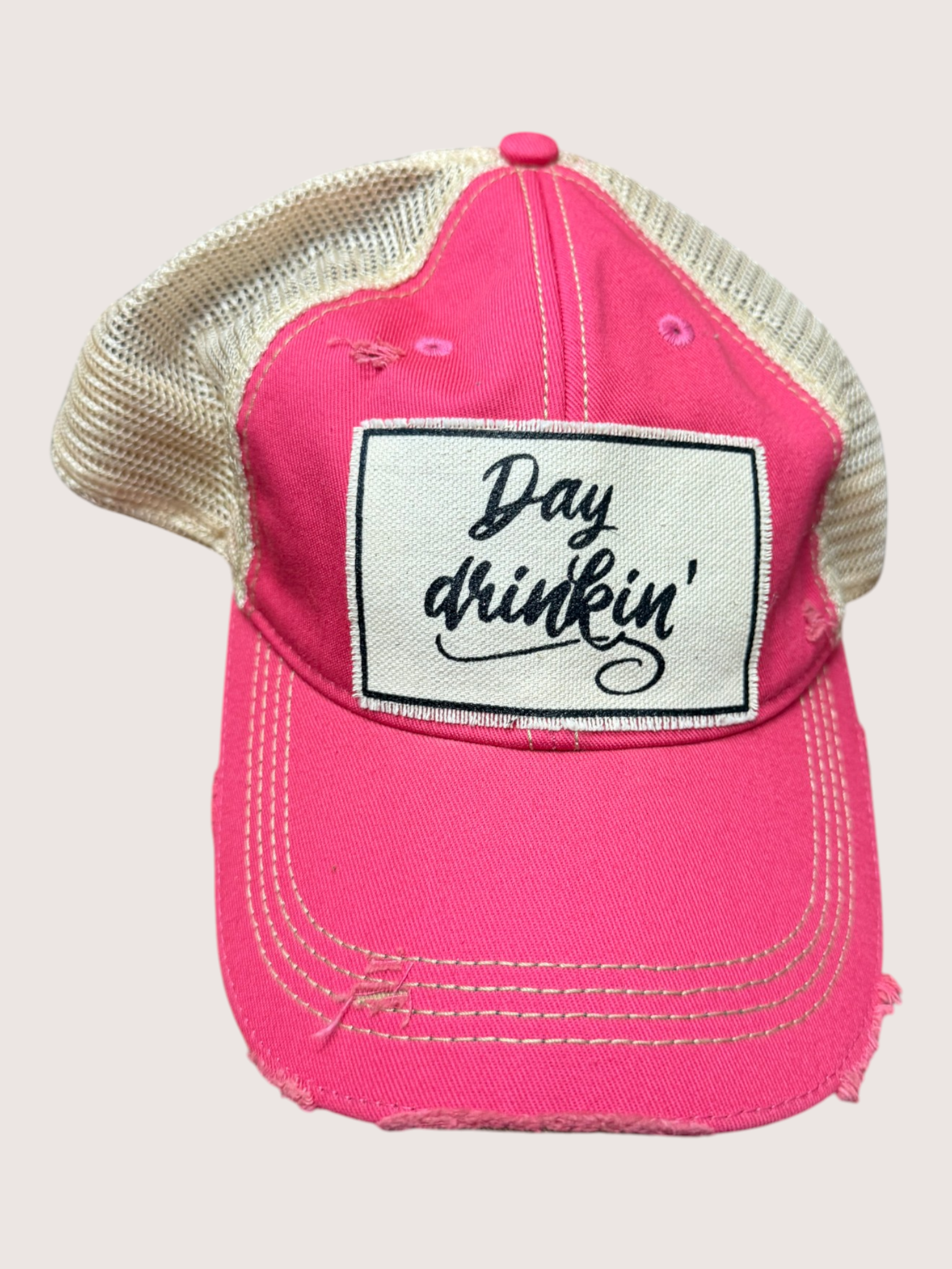 Pink cap with 'Day drinkin'' patch on a light gray background