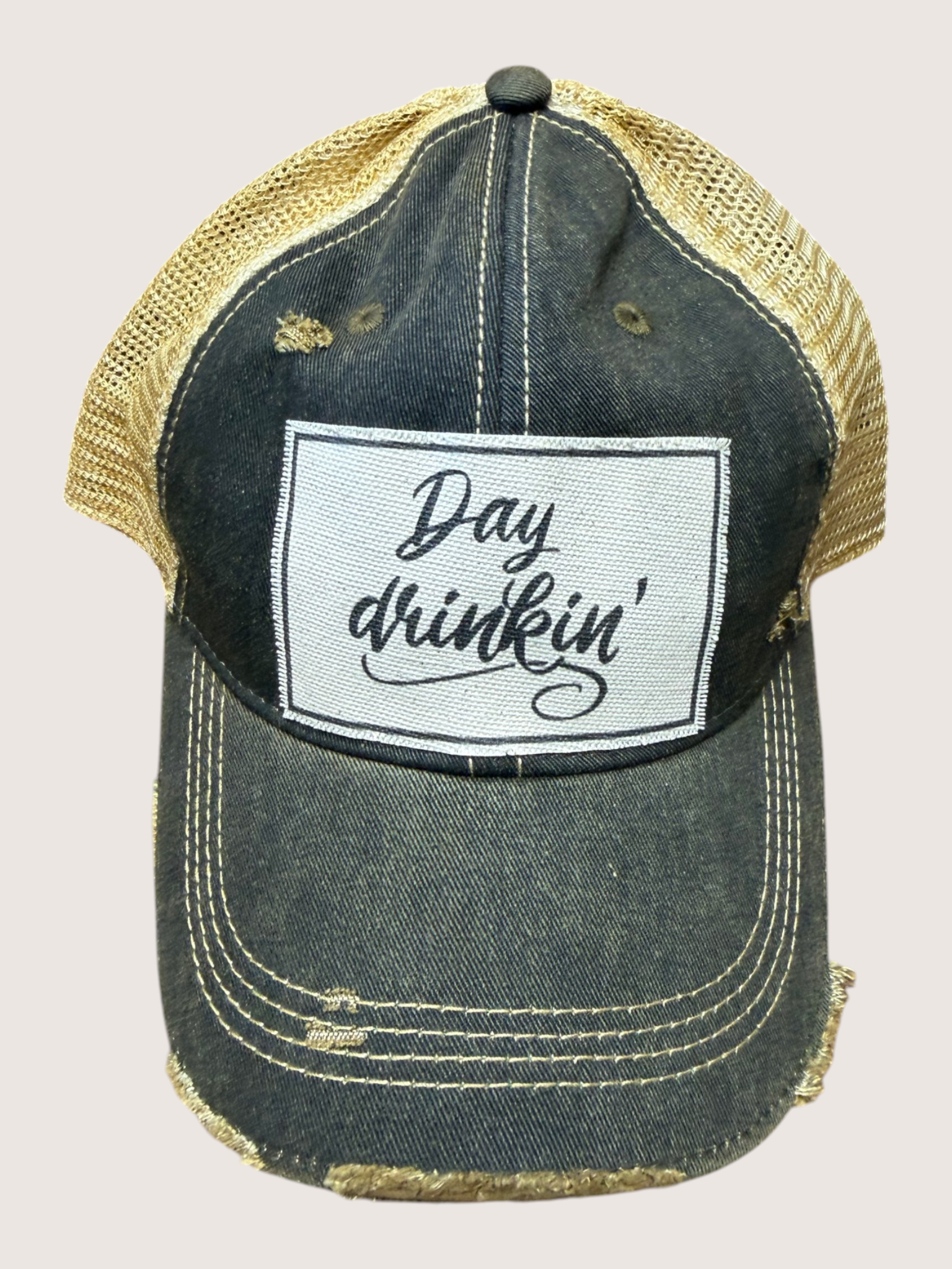 Denim cap with 'Day drinkin'' patch on a beige background
