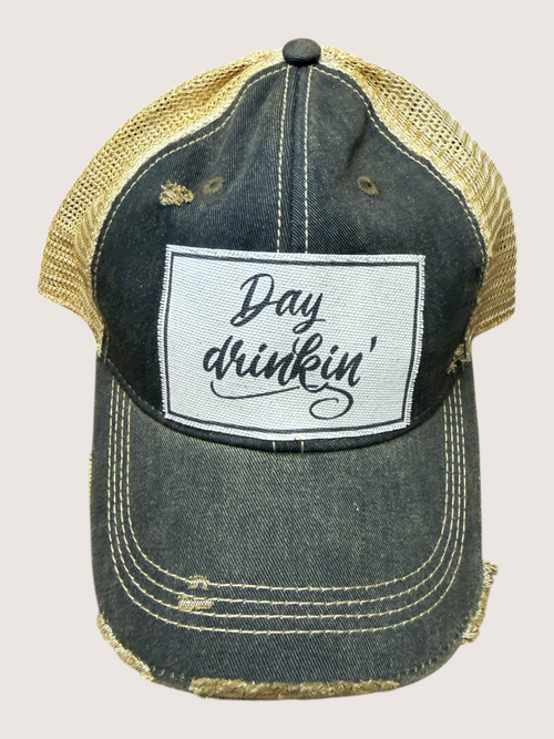 Denim cap with 'Day drinkin'' patch on a beige background