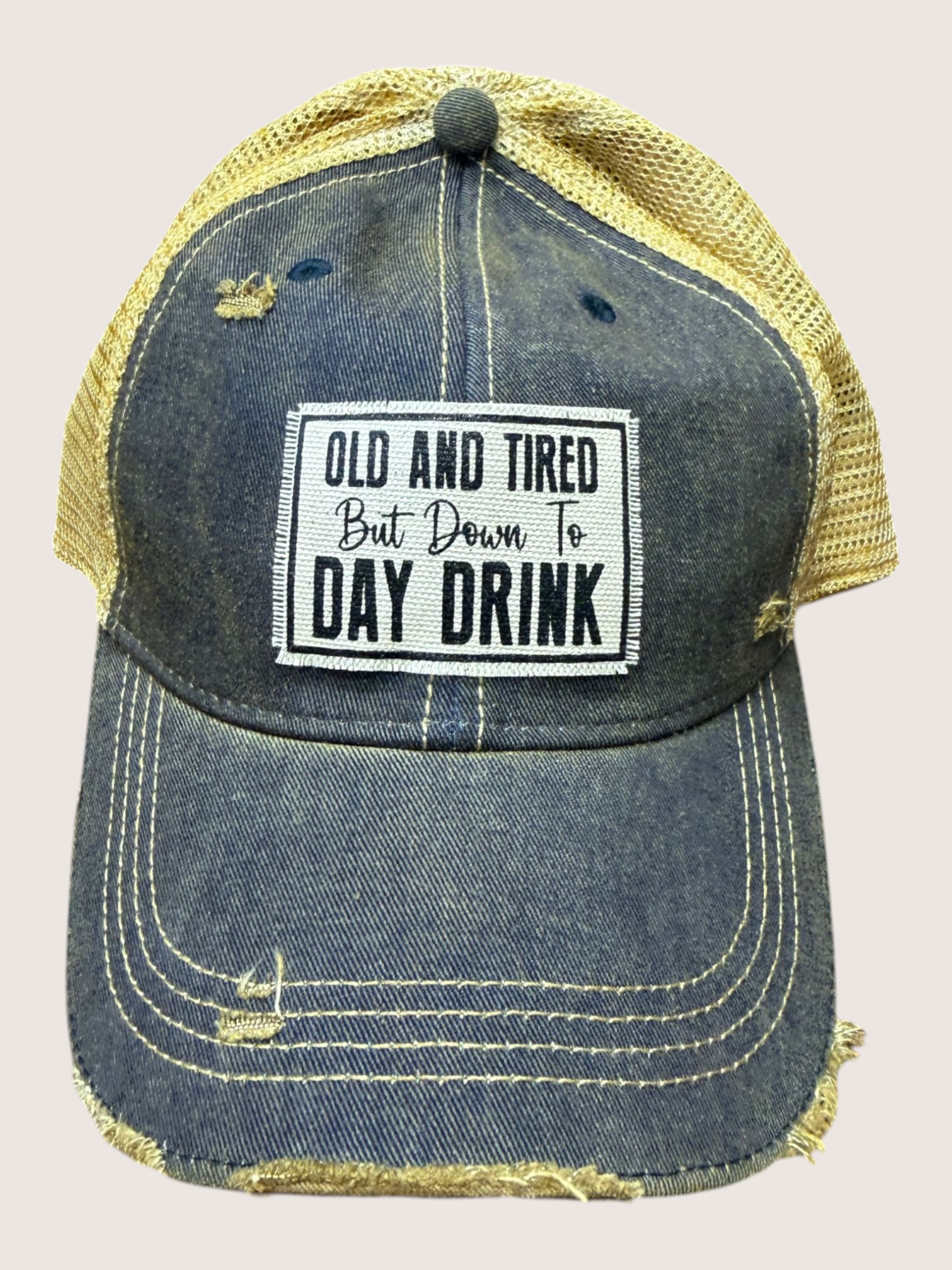 Denim cap with yellow mesh back and text patch on a light gray background