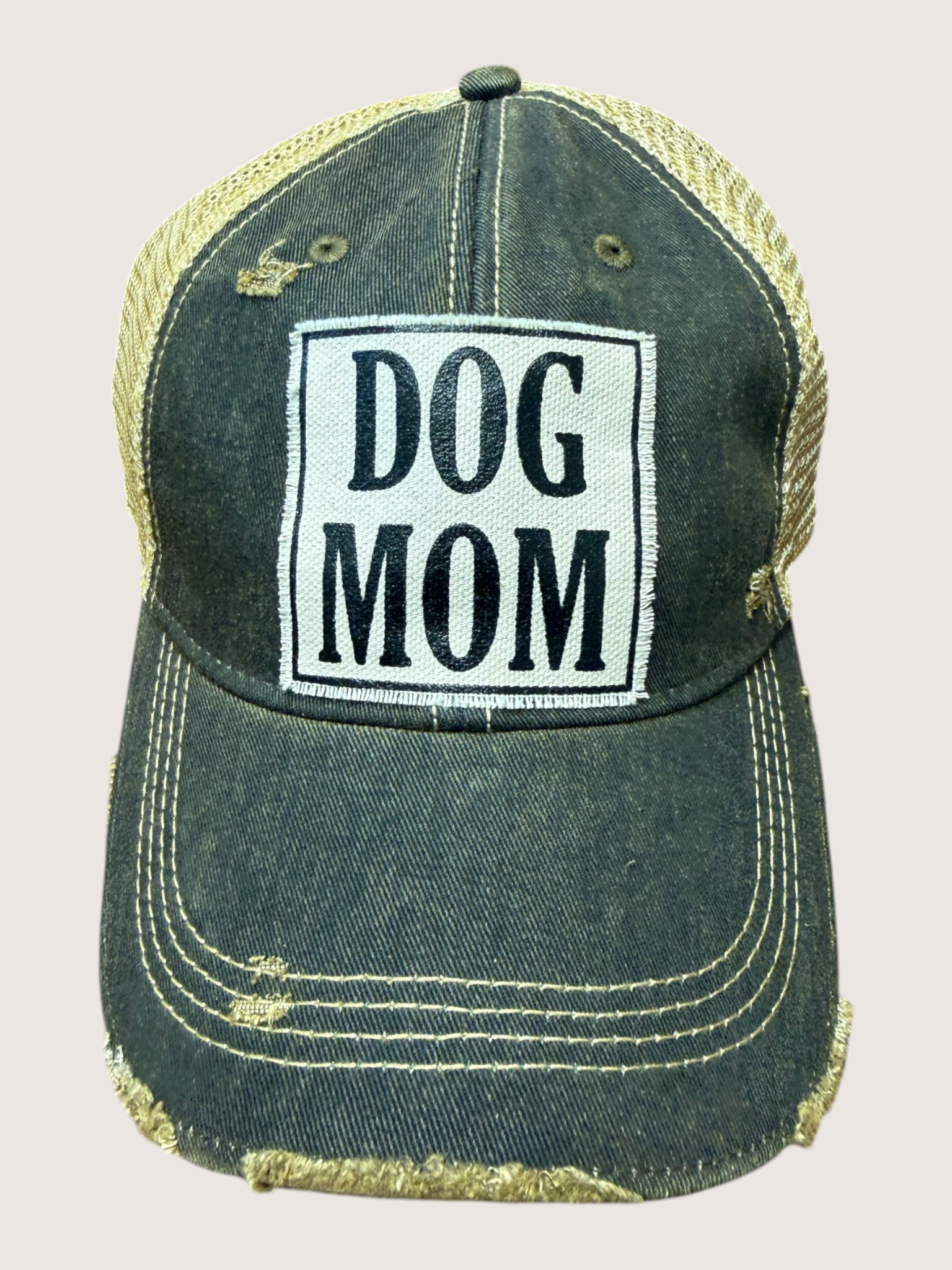 Black and gold cap with 'DOG MOM' text on a light gray background