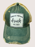 Green and gold cap with a patch that says 'Great minds drink alike' on a light gray background