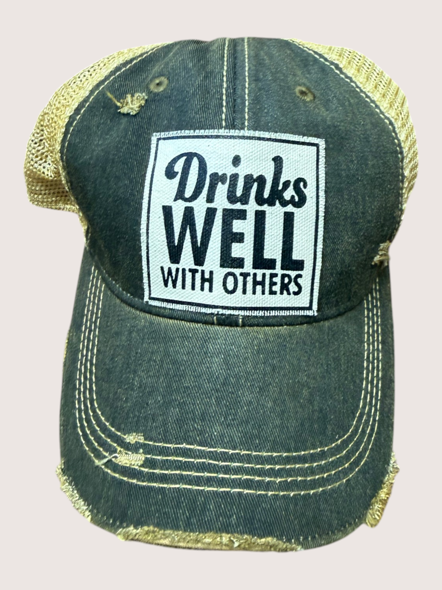 Green cap with 'Drinks Well With Others' text on a light gray background